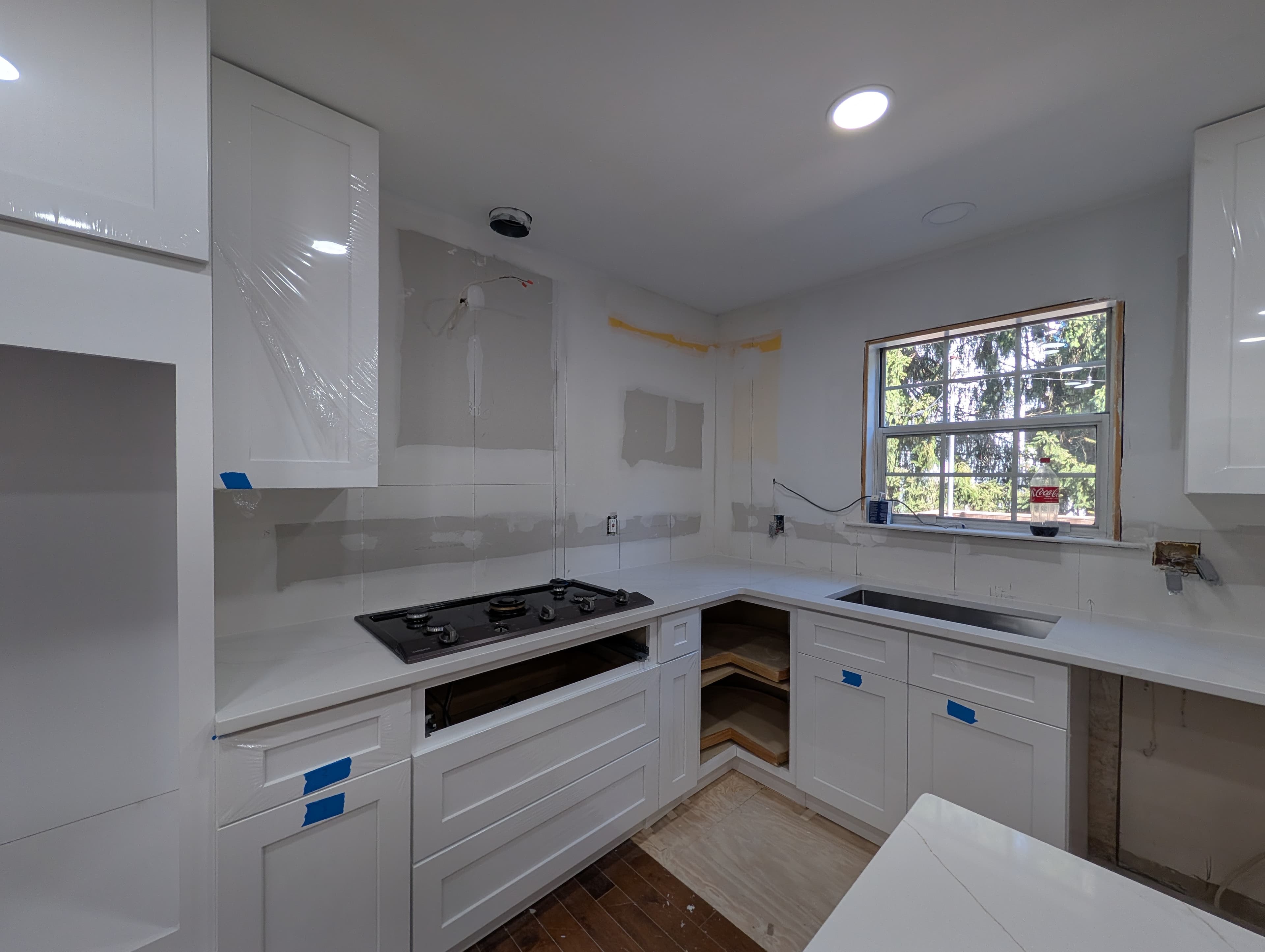 Built-in storage bench and tall cabinetry, wider view, before final paint